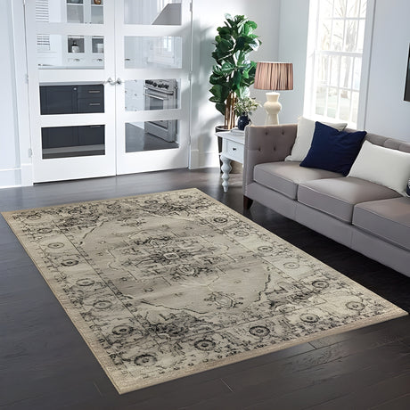 Large size beige and gray vintage-inspired area rug in a modern living room with a gray sofa and dark wood flooring.